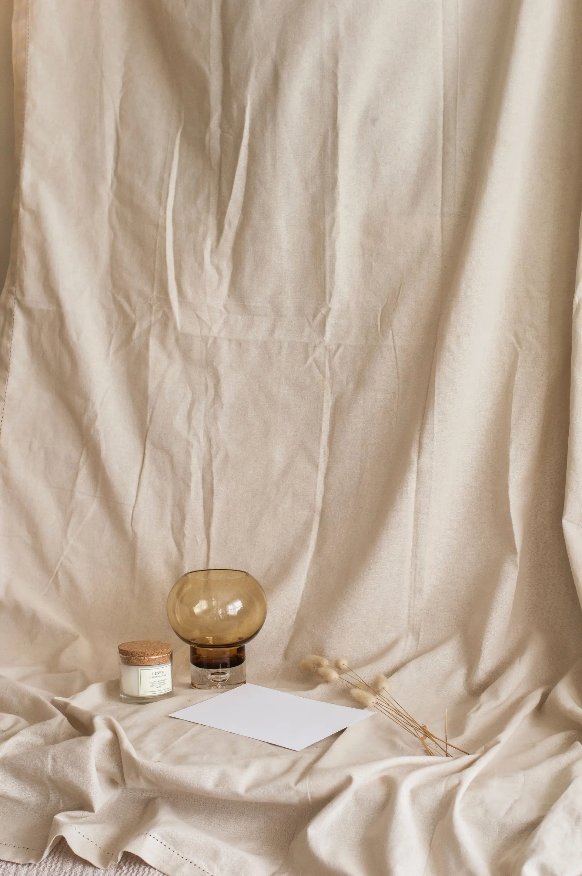 Linen textile background with handcrafted stoneware and neutral styling details