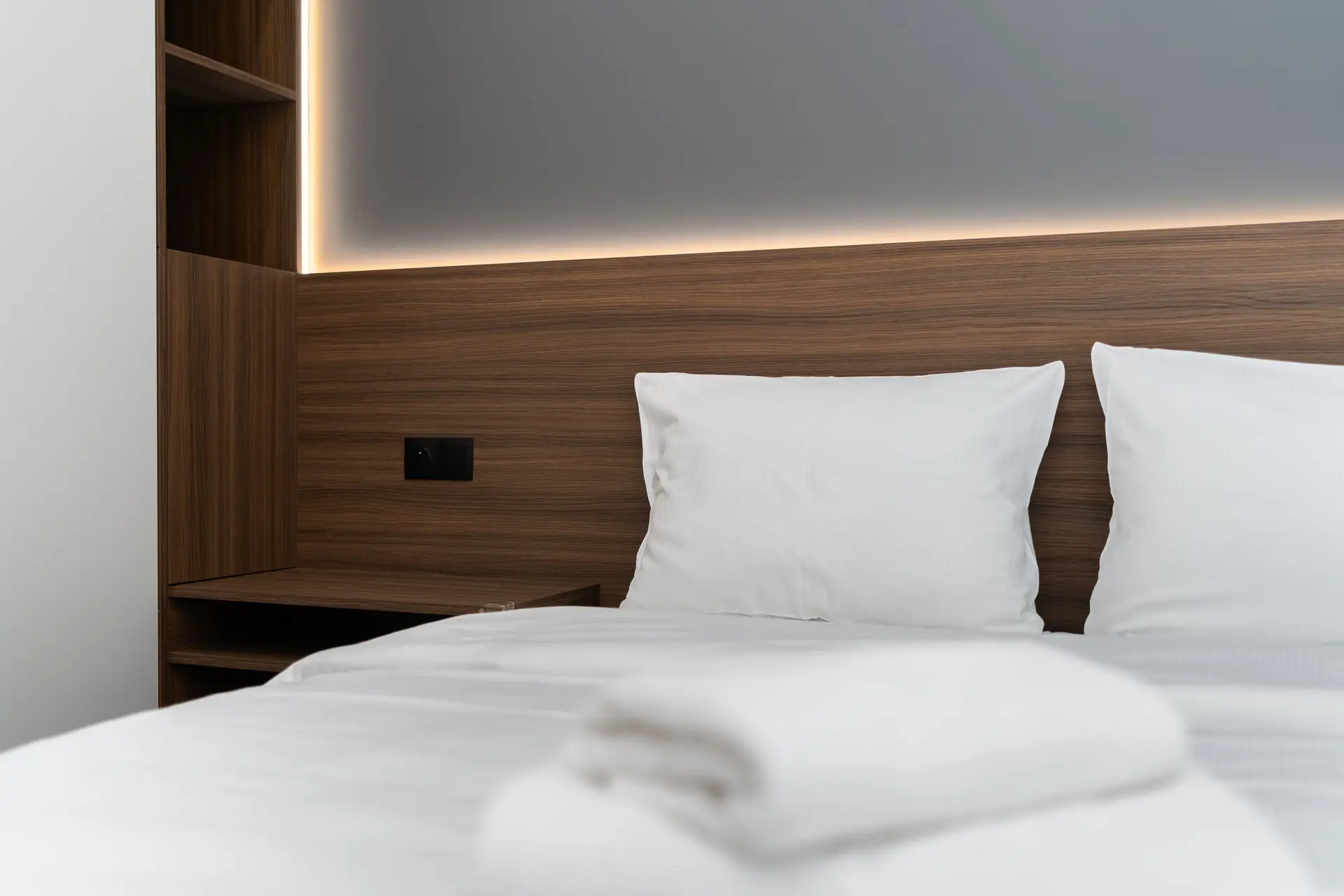 Crisp layered bedroom linens and soft ambient light