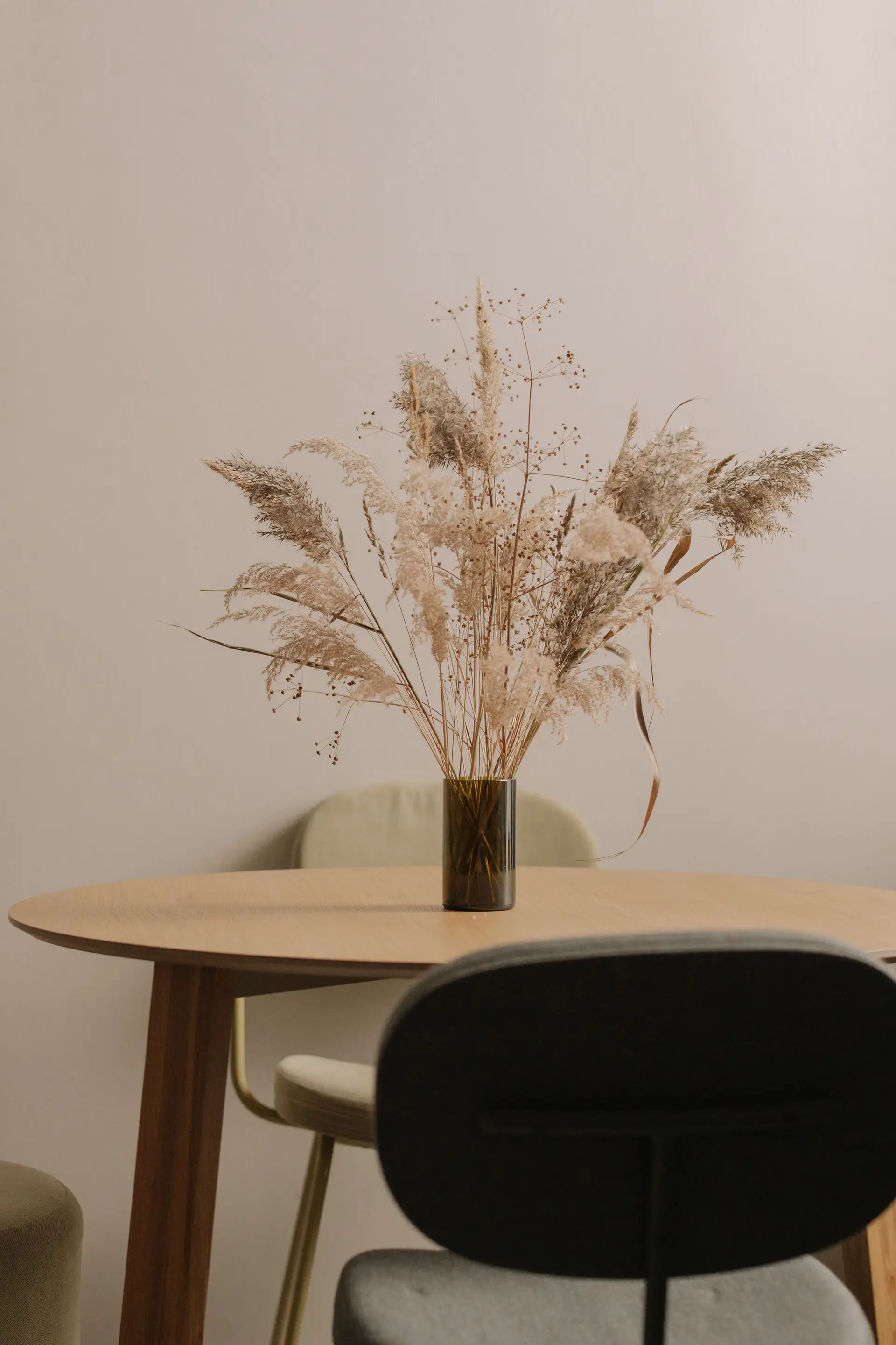 Neutral living room vignette highlighting warm timber table, sculptural ceramic vessel, and balanced daylight